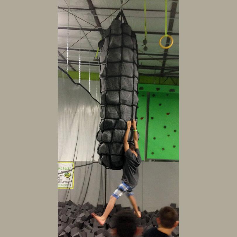 A person is climbing up an obstacle course.